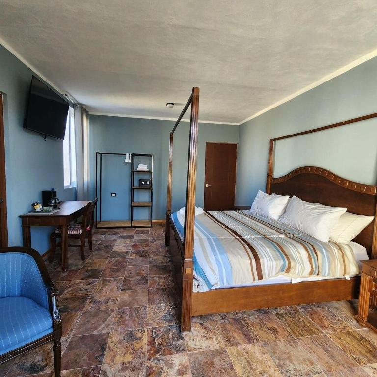 a bedroom with a bed and a desk and a television at Habitación Privada 5min, Centro in Mérida