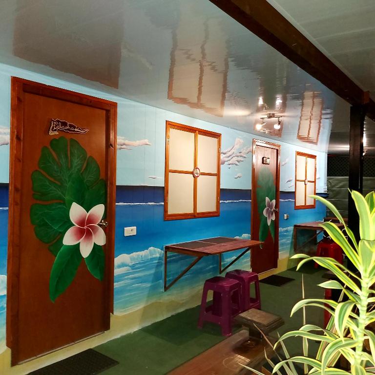 a room with a table and a flower painted on the wall at Moorea Vaiare Lodge in Moorea