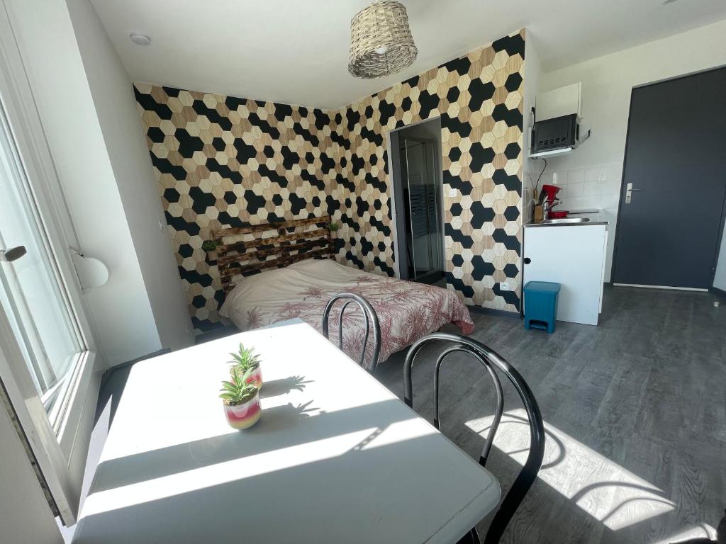 una pequeña habitación con una mesa y una cama en Studio petit plus gaming !, en Calais
