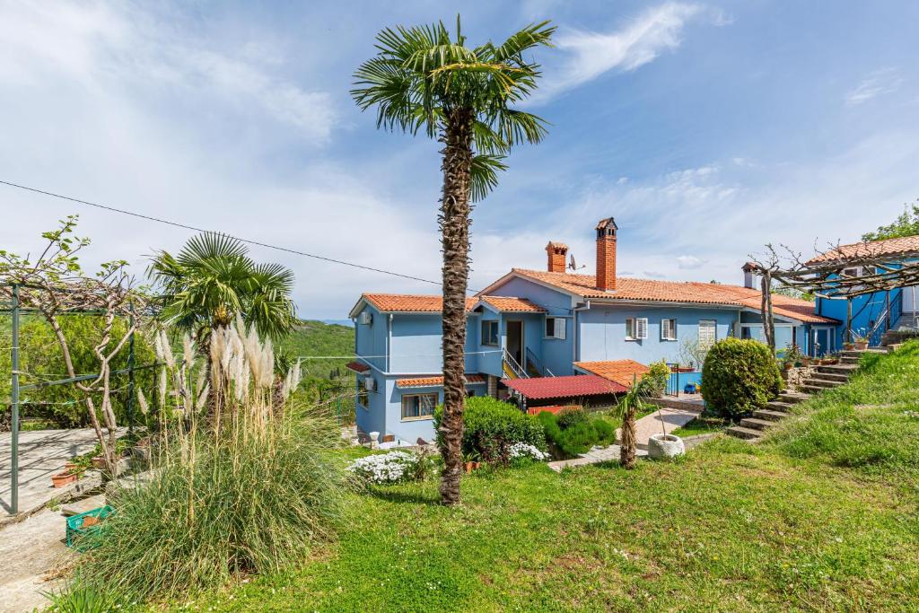 a blue house with palm trees in front of it at Studio Brsec 7796a in Martina