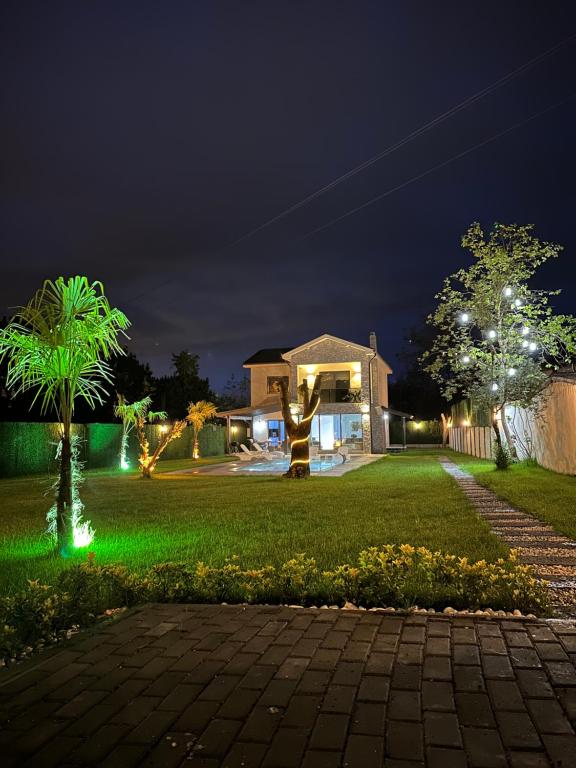a house with a green lawn at night at VİLLOVE Sapanca in Sapanca
