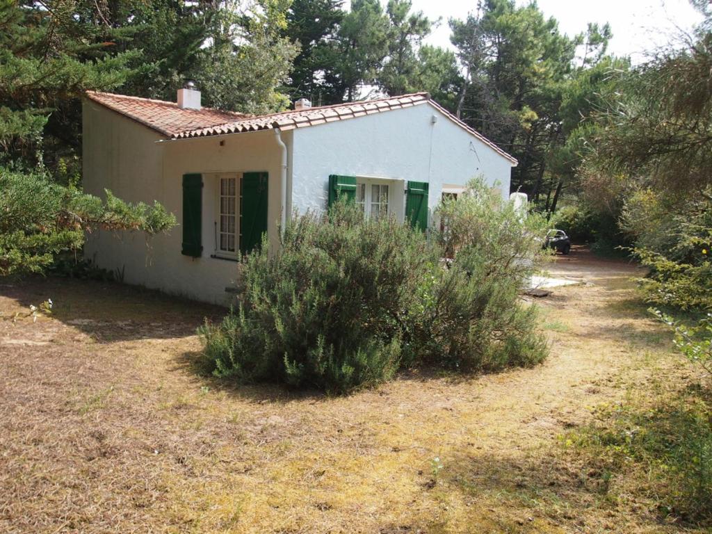 ル・ボワ・プラージュ・アン・レにあるMaison Le Bois-Plage-en-Ré, 2 pièces, 2 personnes - FR-1-258-56の庭に緑の襖を敷く小さな白い家