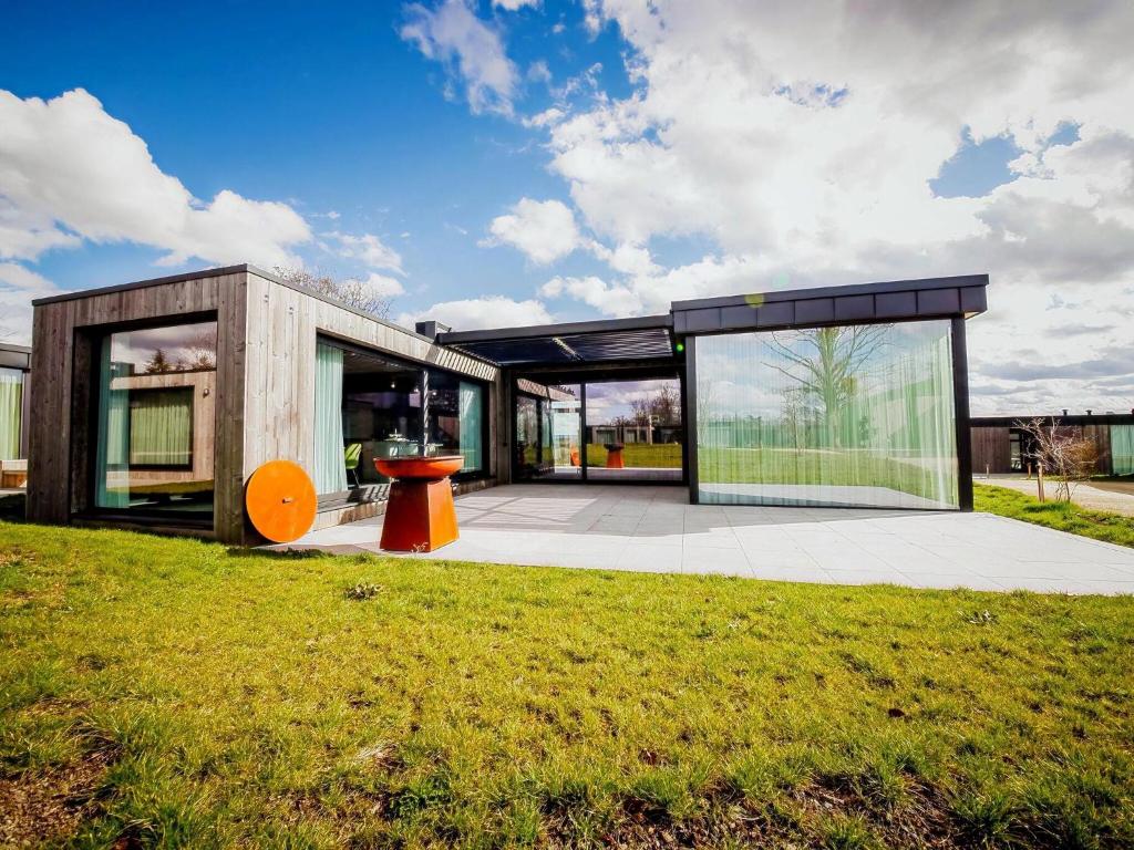 a modern house with glass doors and a lawn at Maison Heurelijk modern finished near Somme-Leuze in Somme-Leuze