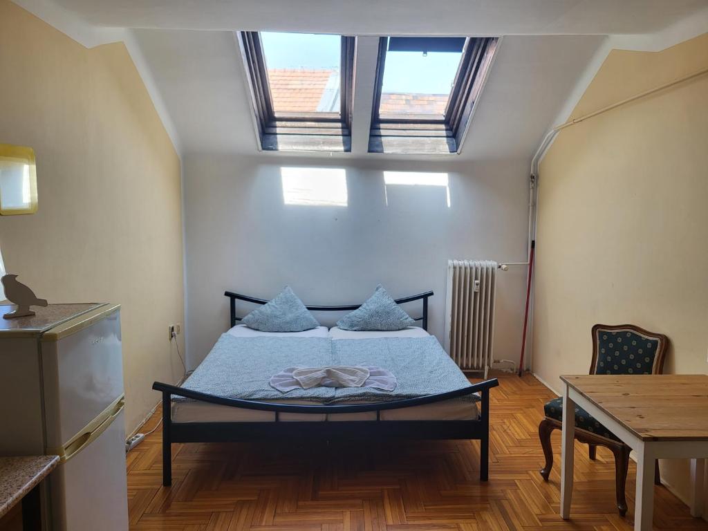 1 dormitorio con 1 cama con sábanas azules y 2 ventanas en Casa Nora en Budapest