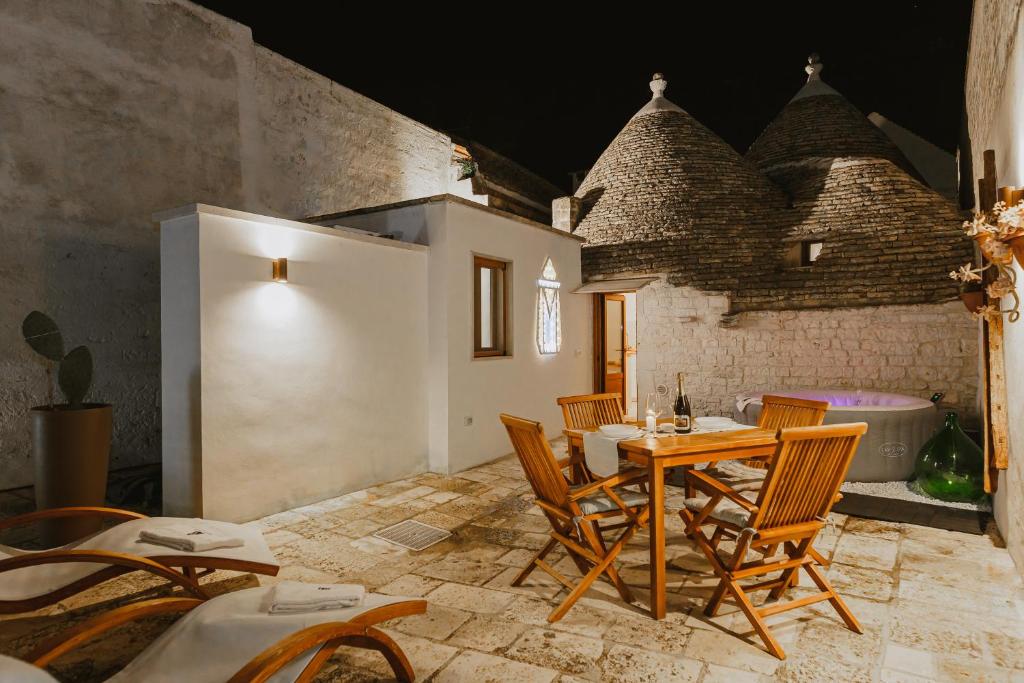 una sala da pranzo con tavolo, sedie e vasca di Milestones Modern Suite Trullo Jacuzzi Spa & Relax ad Alberobello
