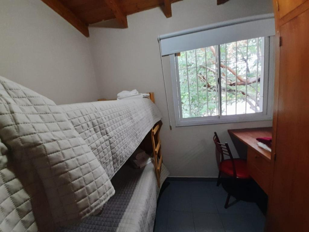 a bedroom with a bed and a window and a desk at Departamento Los Girasoles in Guaymallen