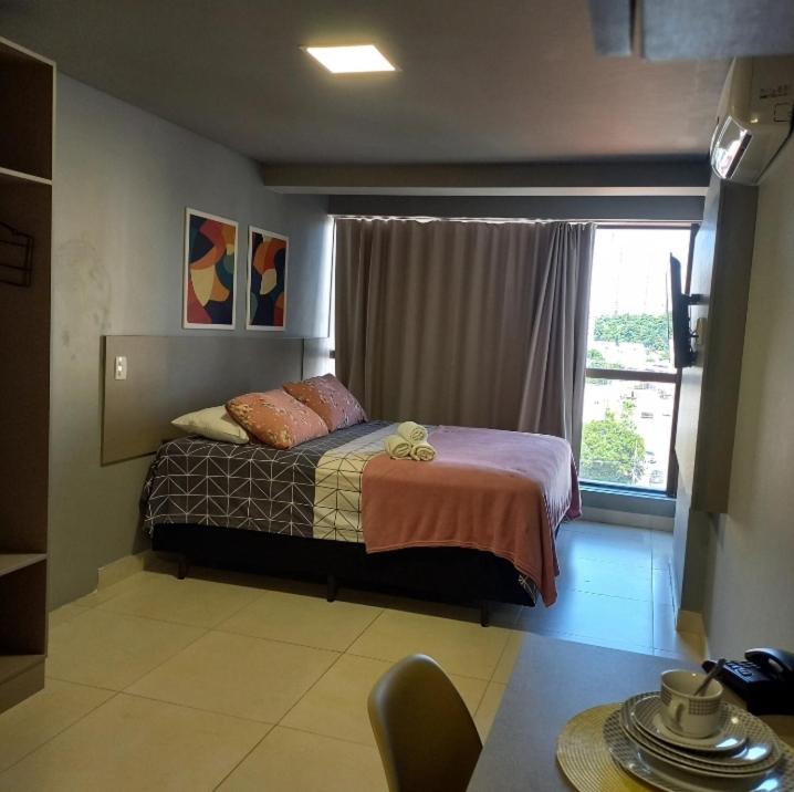 um quarto com uma cama em frente a uma janela em Flat encantador no Manaira Apart Hotel 1301 em João Pessoa