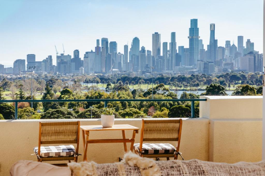 uma varanda com uma mesa e cadeiras e um horizonte da cidade em Spectacular views over Albert Park em Melbourne