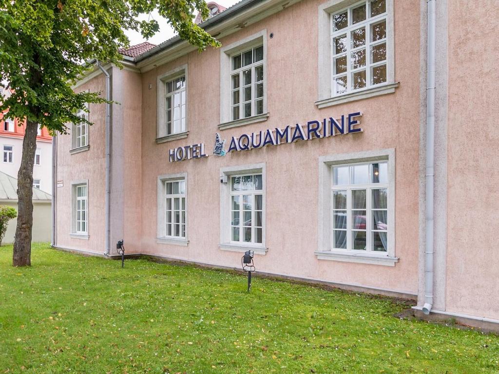 un edificio rosa con una señal que lee la avalancha del hotel en Aquamarine Hotel - Lauluväljak en Tallin