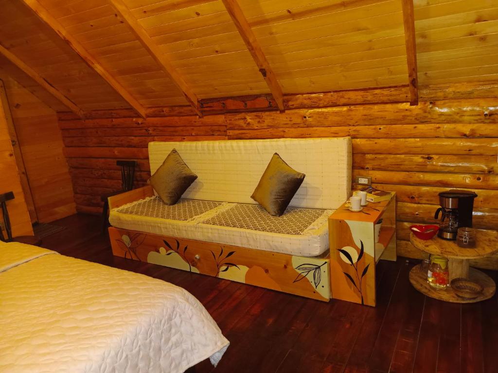 1 cama en una cabaña de madera con 2 almohadas en Glamping El Ocaso, en Zipaquirá