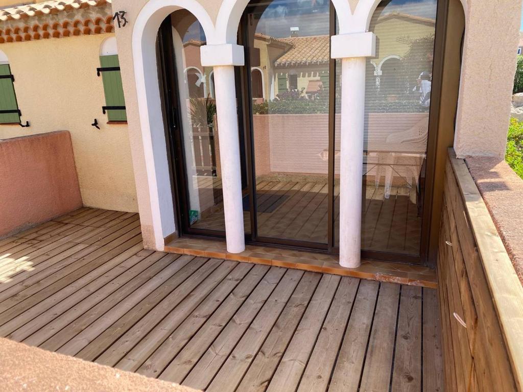 a screened in porch with a wooden deck at Villa Port Barcarès, 2 pièces, 4 personnes - FR-1-81-259 in Le Barcarès