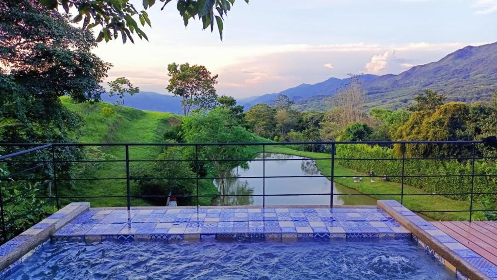 a swimming pool with a view of a river and mountains at Casa Ensueño Campestre in Guaduas