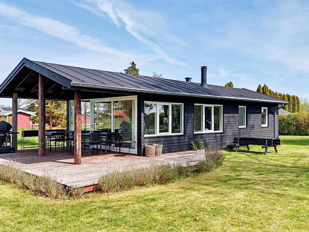 ein blaues Haus mit einer Veranda und einem Picknicktisch in der Unterkunft Holiday home Karrebæksminde IX in Karrebæksminde