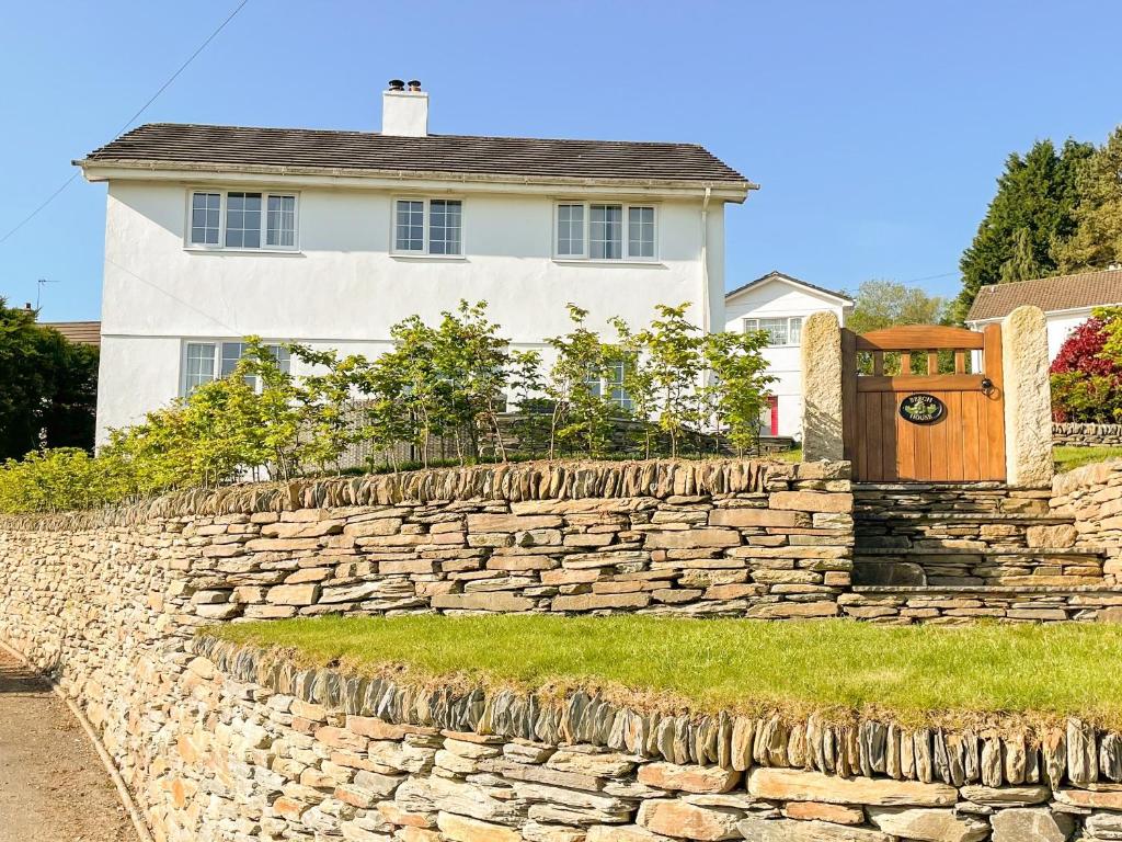 a stone retaining wall in front of a house at Beech House in Sydenham Damerel