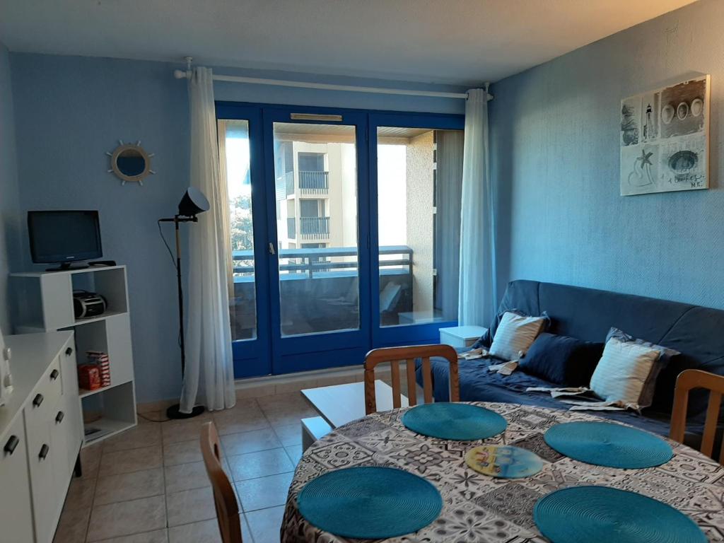 a living room with a table and a couch at Appartement Seignosse, 1 pièce, 4 personnes - FR-1-239-400 in Seignosse