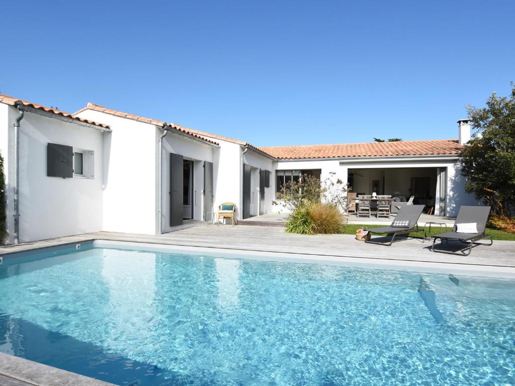 a villa with a swimming pool in front of a house at Villa Sainte-Marie-de-Ré, 5 pièces, 8 personnes - FR-1-258-76 in Sainte-Marie-de-Ré