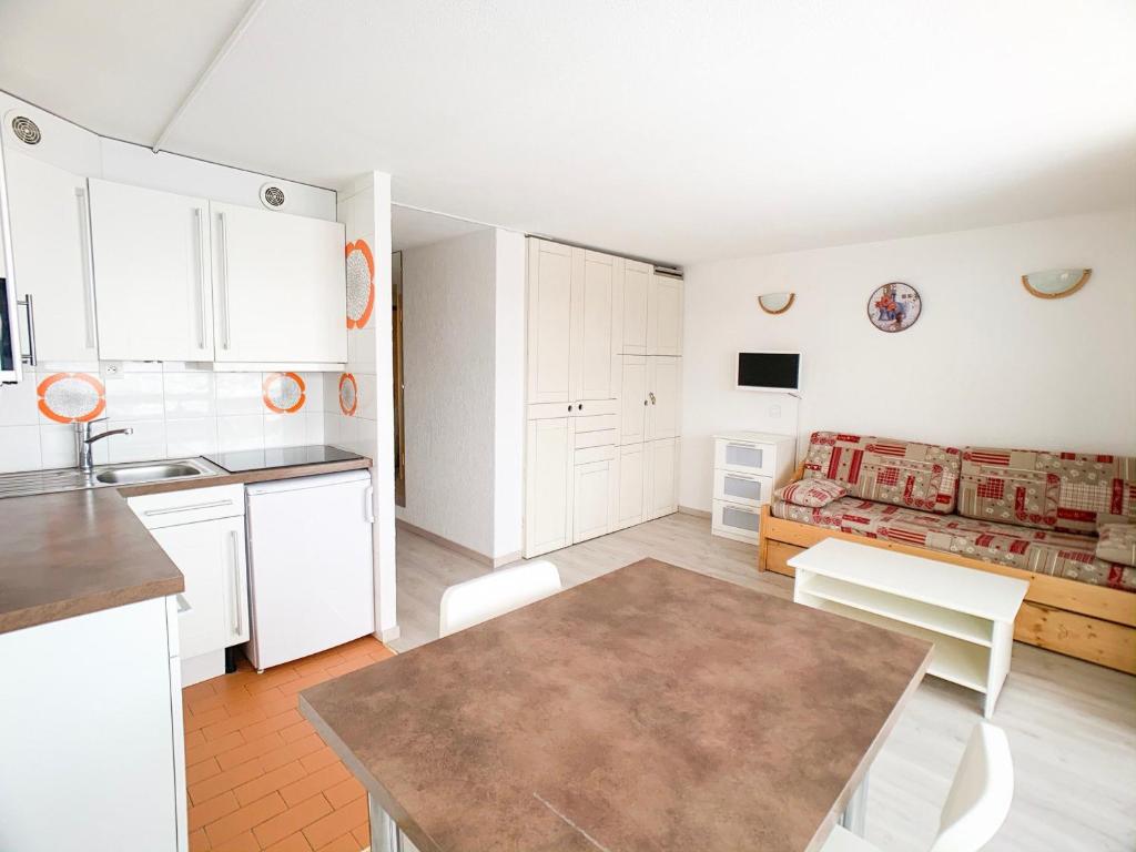 a kitchen and living room with a table and a couch at Proche commerces et pistes · Appartement lumineux avec balcon · 2 pièces pour 6 personnes - FR-1-502-503 in Tignes