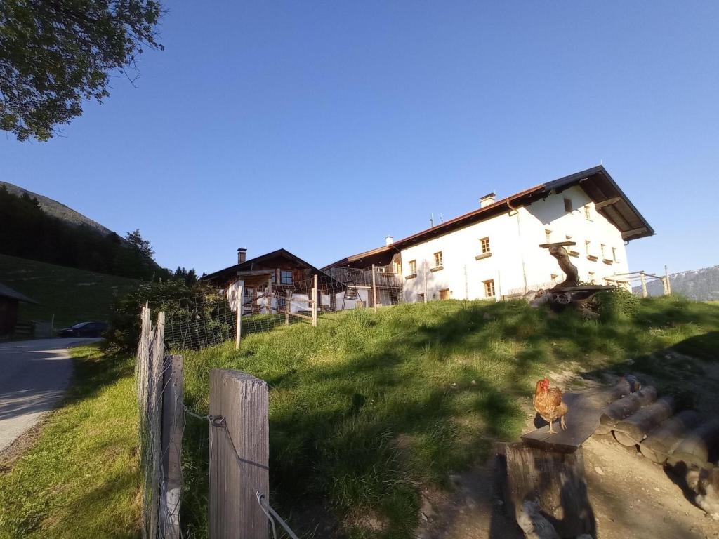 uma casa no topo de uma colina com uma cerca em Roßweid hut with a fantastic view em Stans