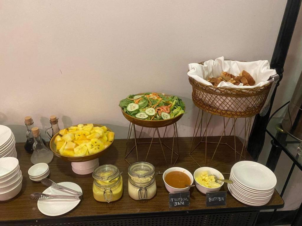 une table avec des assiettes et des bols de nourriture dans l'établissement Summit Hotel Magnolia, à Manille