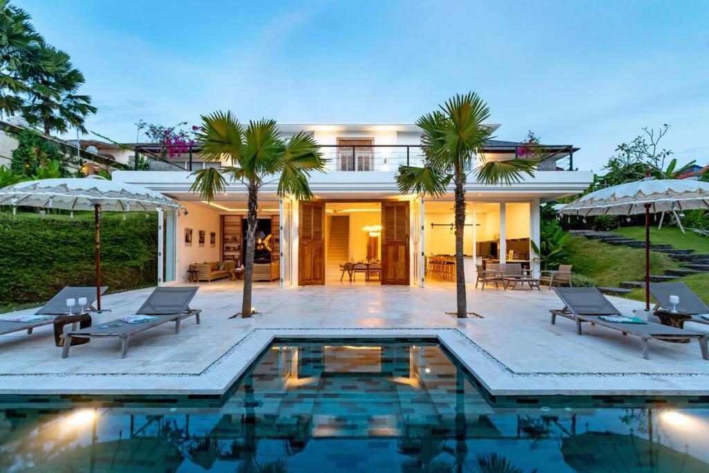 una casa con piscina e palme di Luxurious & Spacious family Villa in Canggu a Dalung