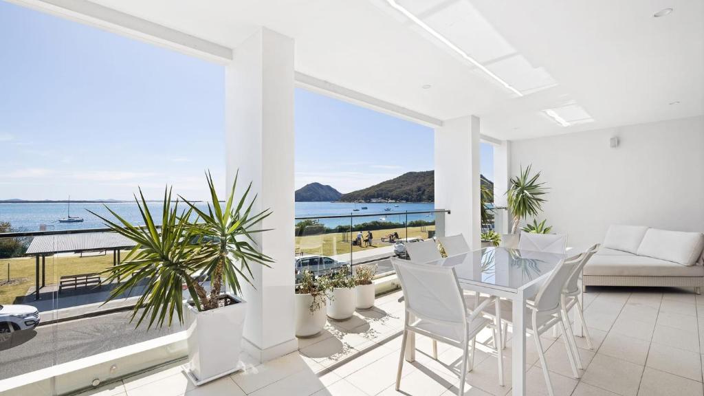 a white dining room with a view of the ocean at Aura 2 apartment with Spectacular Views in Shoal Bay