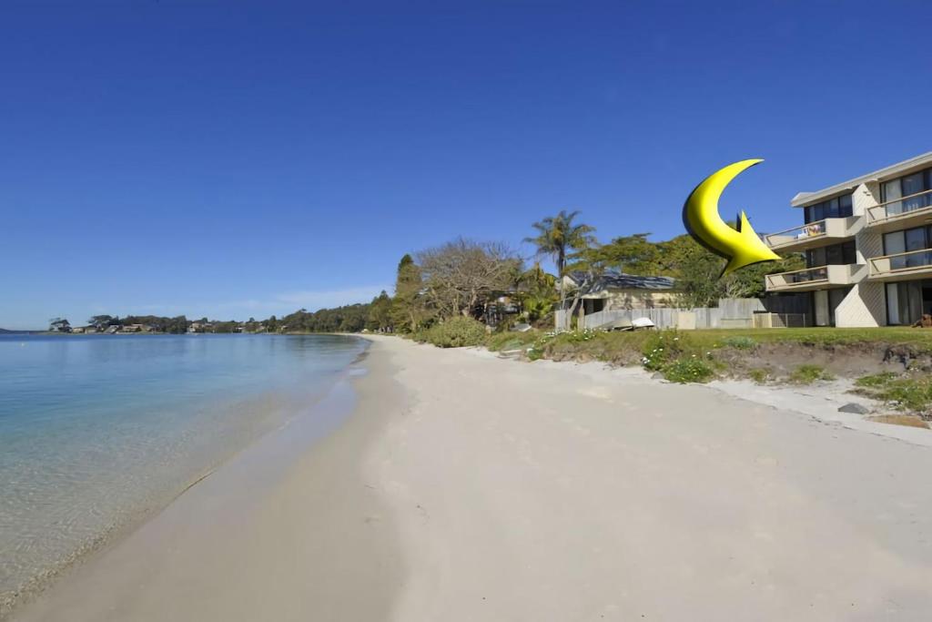 a view of a beach with a yellow crescent moon at Gorgeous Harbourside in Soldiers Point