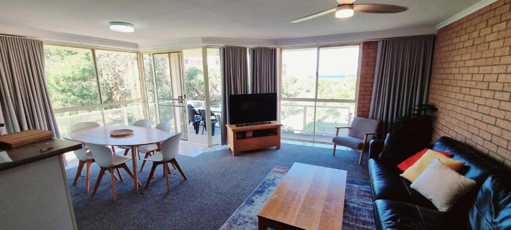 een woonkamer met een bank en een tafel bij Seaspray Walk to the beach in Nelson Bay