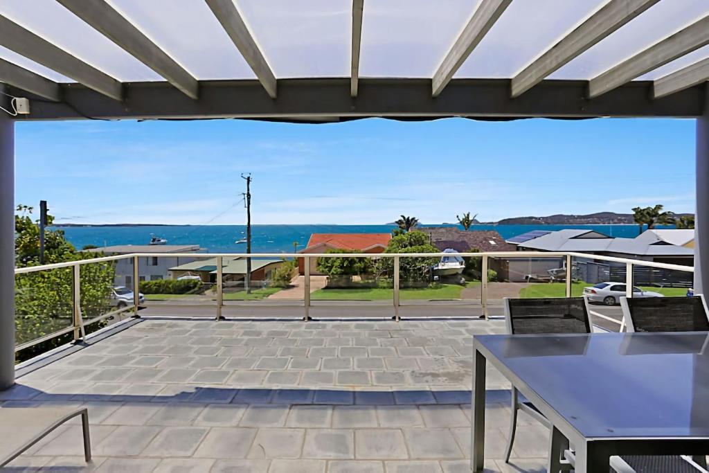 a patio with a view of the ocean at Views of Wanda Beach in Salamander Bay