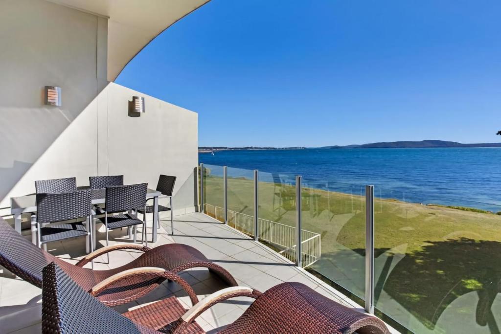 a balcony with chairs and a view of the ocean at Breath Taking Waterfront in Corlette
