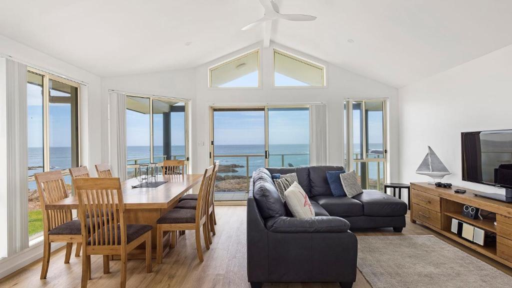 a living room with a table and a couch at Absolute Waterfront Anna Bay in Anna Bay