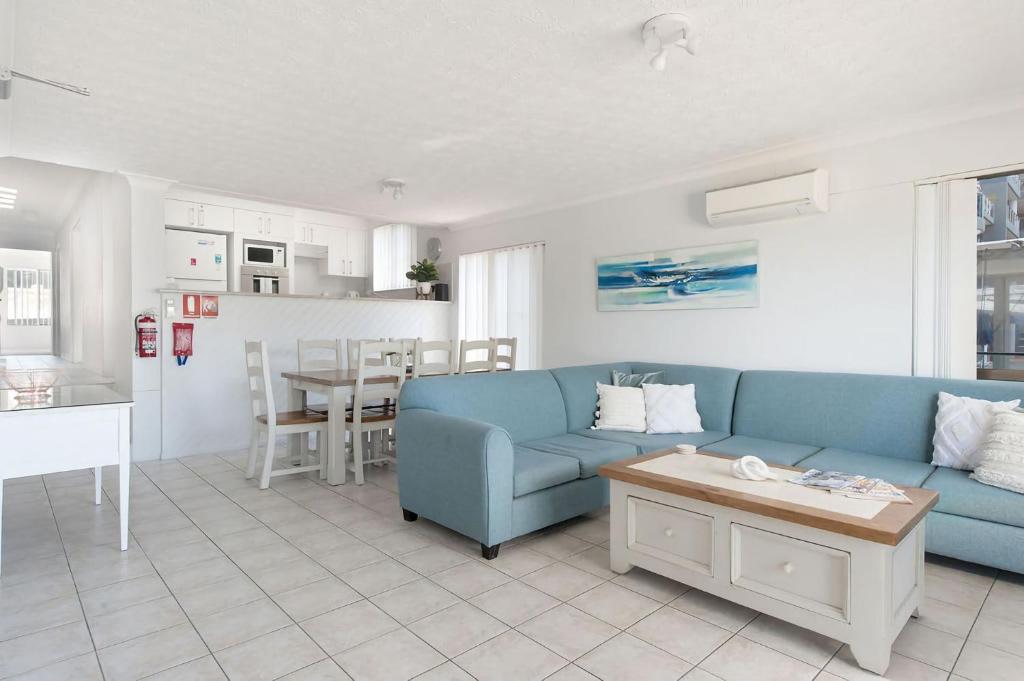 a living room with a blue couch and a table at Great Location in Nelson Bay in Nelson Bay