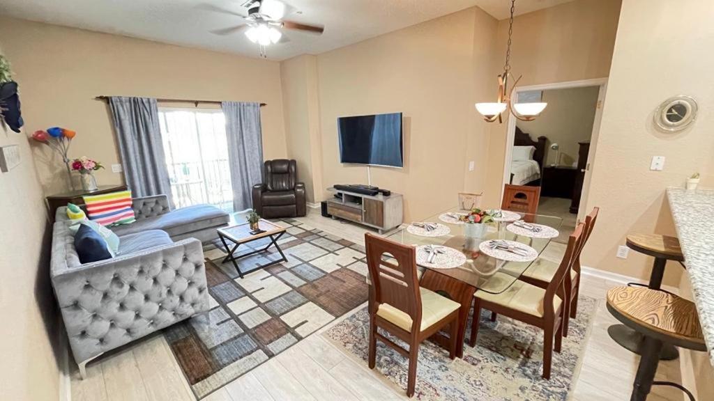een woonkamer met een tafel en een eetkamer bij Beautiful 3 Bedroom Apartment minutes from Disney! in Kissimmee