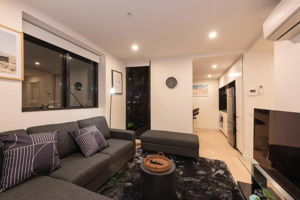 sala de estar con sofá y TV en COZY Melbourne Southbank - 2 Bedroom Apartment with Balcony & FREE Parking, en Melbourne