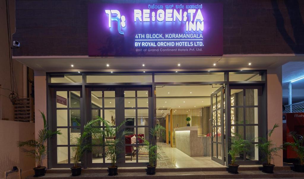 バンガロールにあるRegenta Inn 4th Block Koramangala Bangaloreの紫の看板が目の前にある建物
