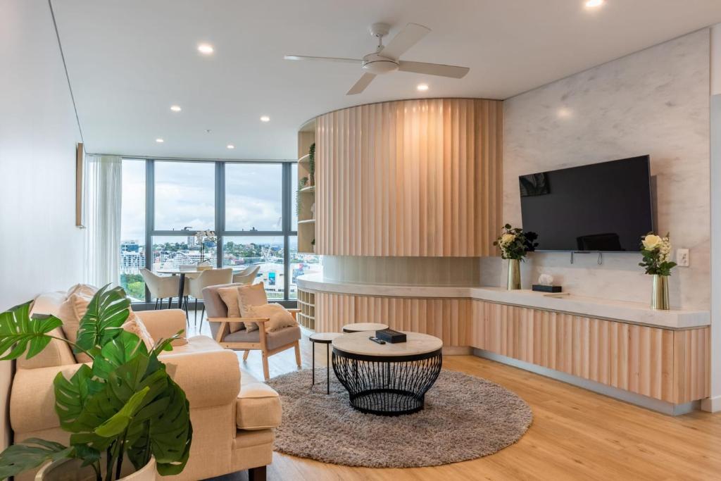 a living room with a couch and a tv at Ultimate Riverview Designer 2BD Apartment at CBD in Brisbane