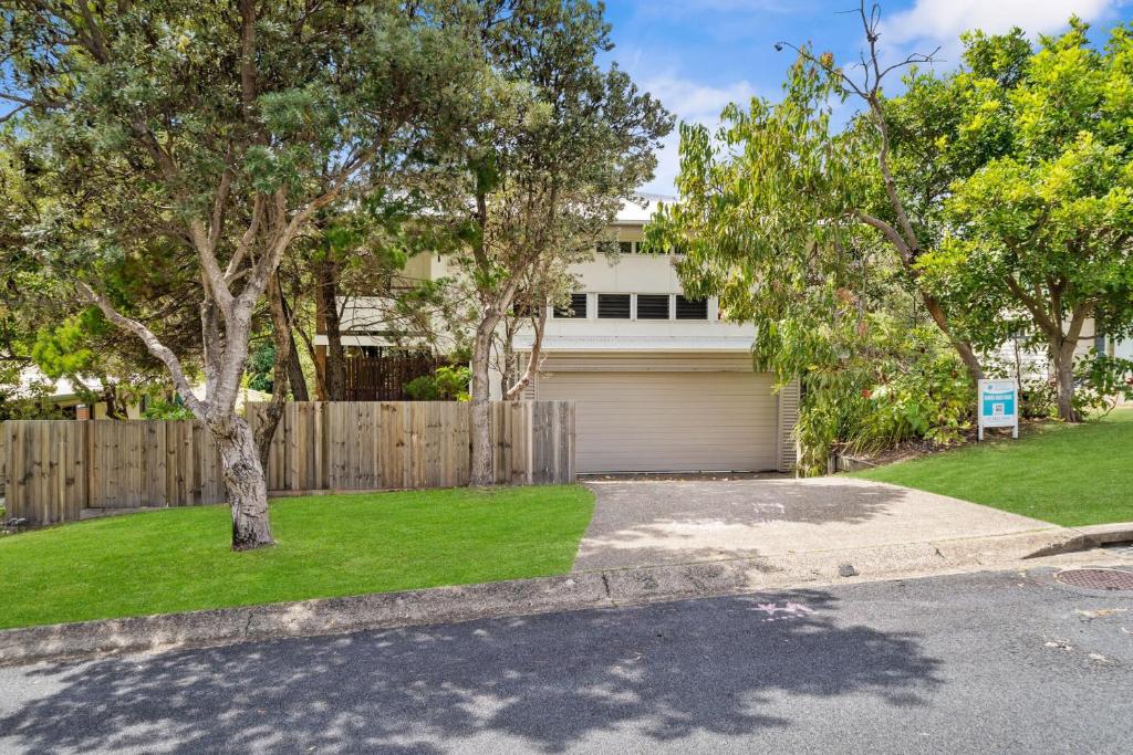 una casa con una cerca y un patio con entrada para autos en Banksia Beach House by Discover Stradbroke, en Point Lookout