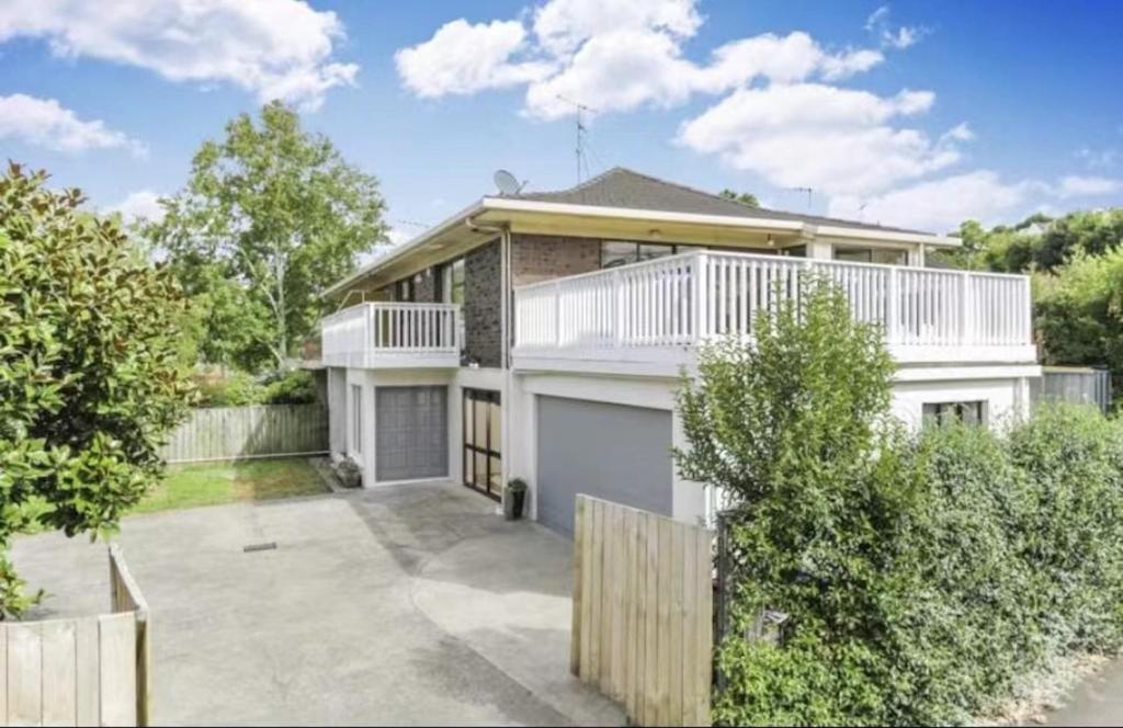 una gran casa blanca con una valla delante en Scherff Road Holiday Home en Auckland