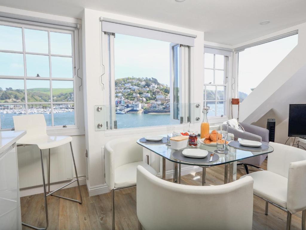 un soggiorno con tavolo, sedie e finestre di Kings View a Dartmouth