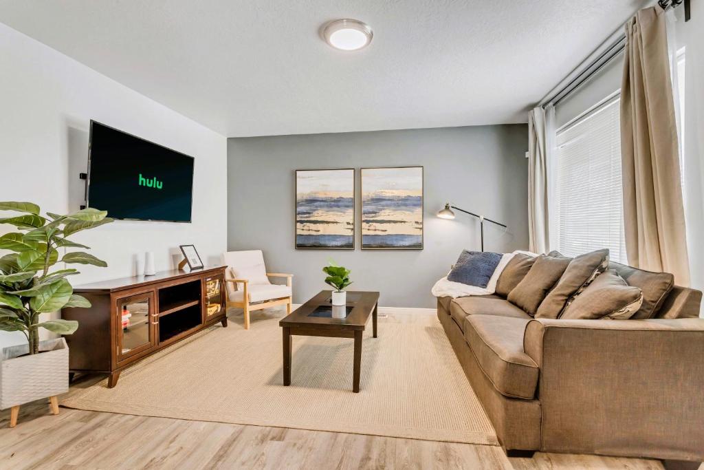 uma sala de estar com um sofá e uma televisão em King Bed - Fast WiFi - Sugarhouse Health Center em Salt Lake City