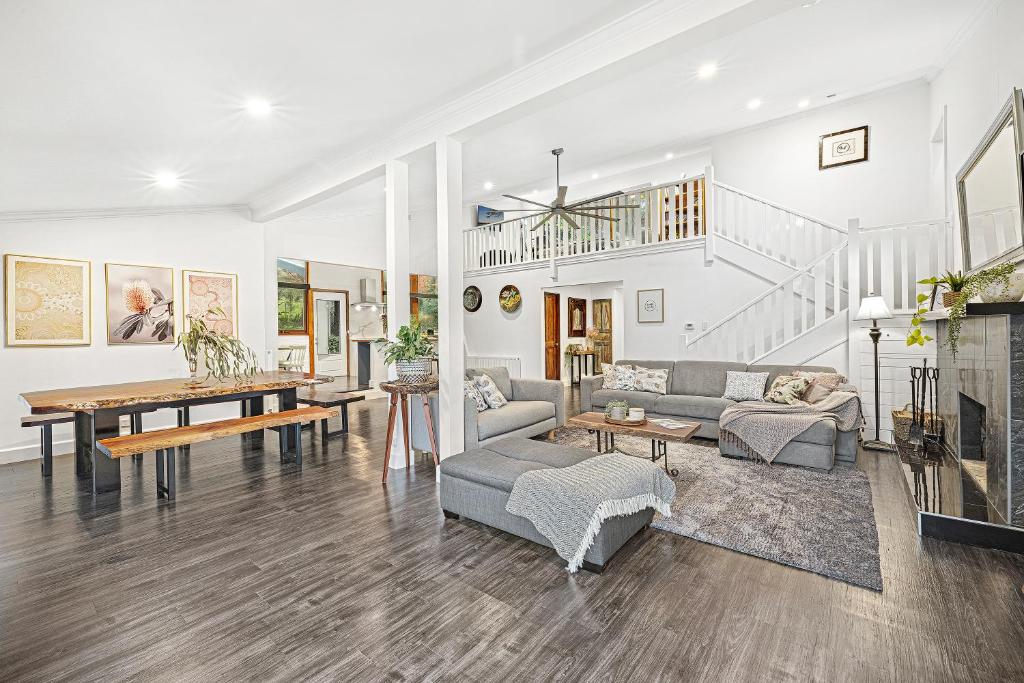 a living room filled with furniture and a table at Sherbrooke Forest Retreat - Noonameena Home in Sherbrooke