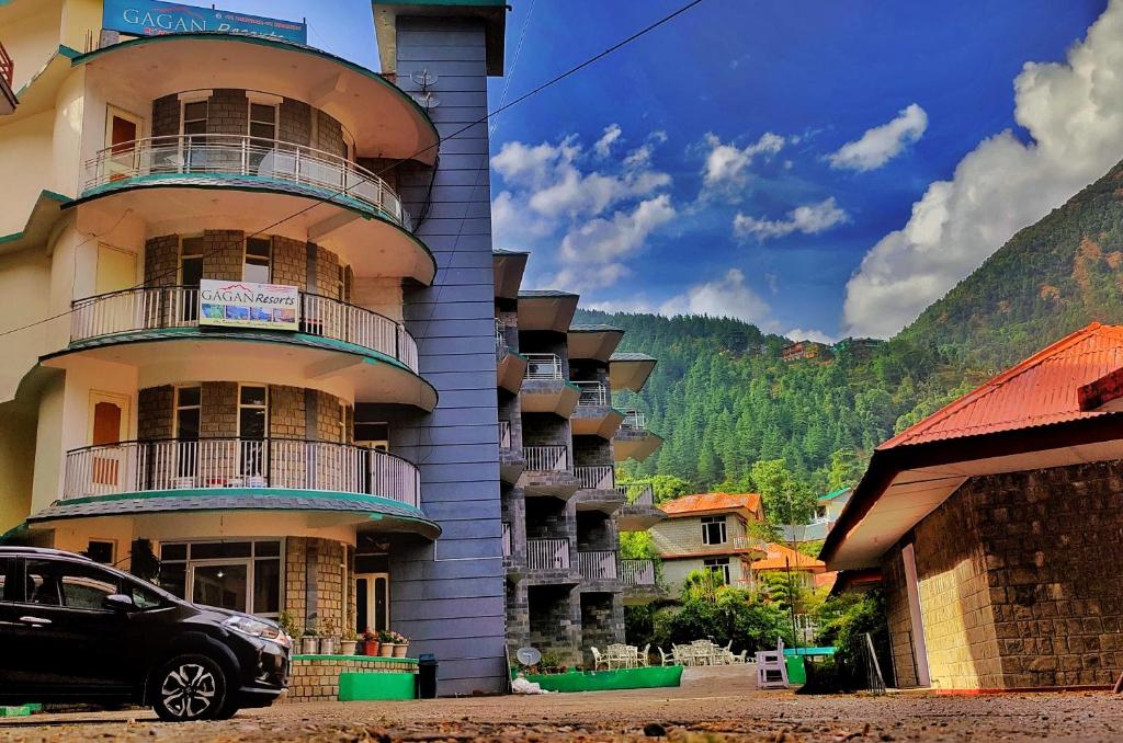 a building with a car parked in front of it at Gagan Resorts in Dharamshala