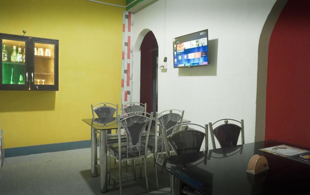 a room with chairs and a table and a tv at Drishtee Homestay in Rongli