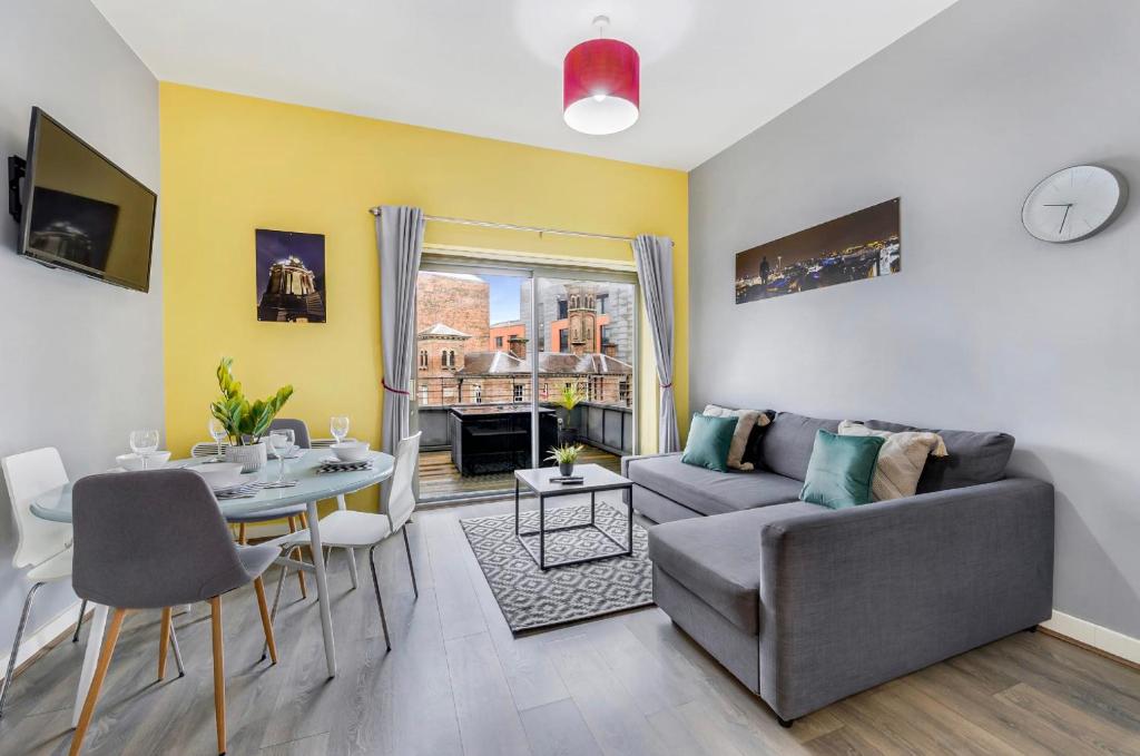 a living room with a couch and a table at Host & Stay - Campbell Square Roof Terrace Apartment in Liverpool