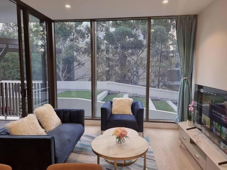 a living room with two couches and a tv at Sapphire Royale Suite in Macquarie Park in Sydney