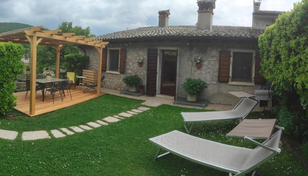 a backyard with a table and chairs and a patio at Casa Vacanze MODENA in Costermano