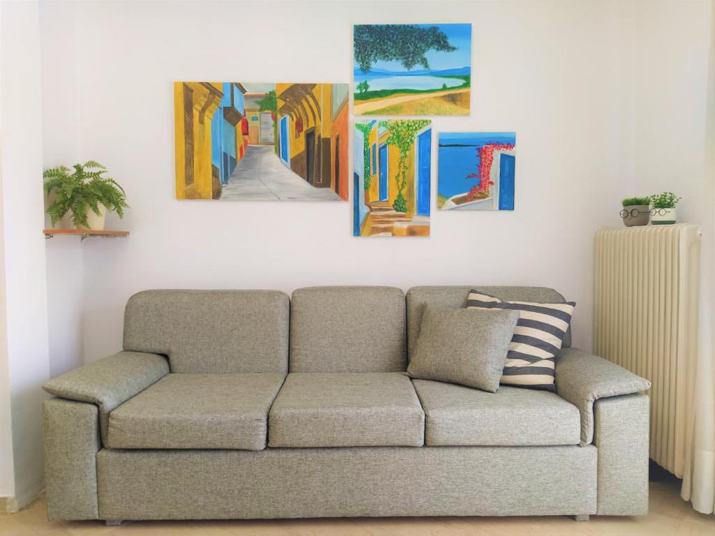 a living room with a couch and paintings on the wall at Sunset Studios Kavala in Kavála