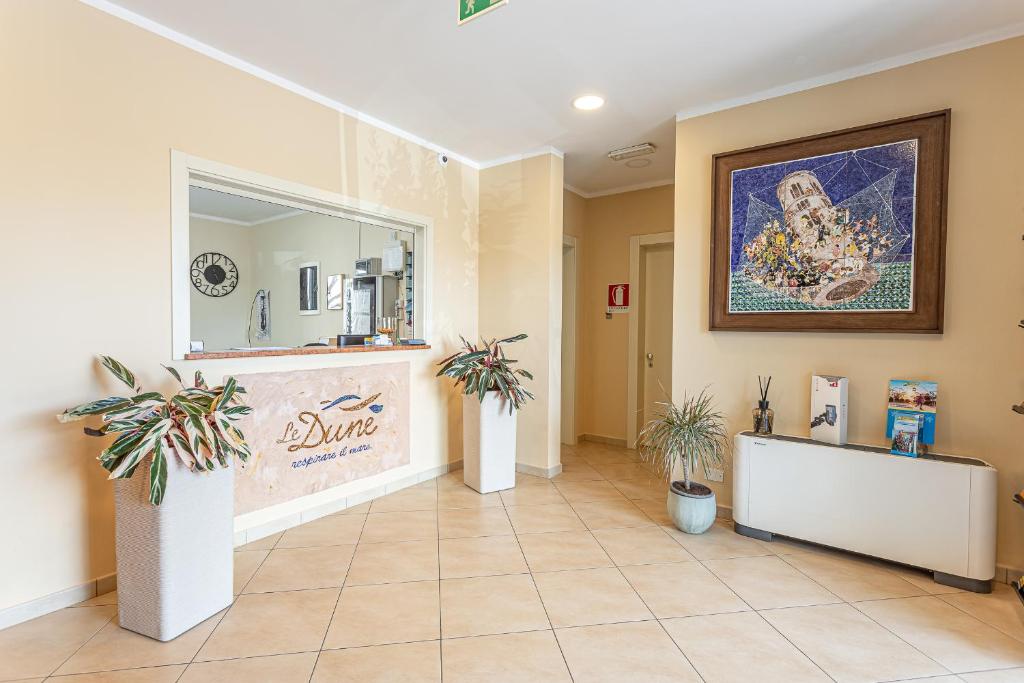 een lobby met potplanten en een spiegel bij Hotel Residence Le Dune breakfast included in Lido Adriano