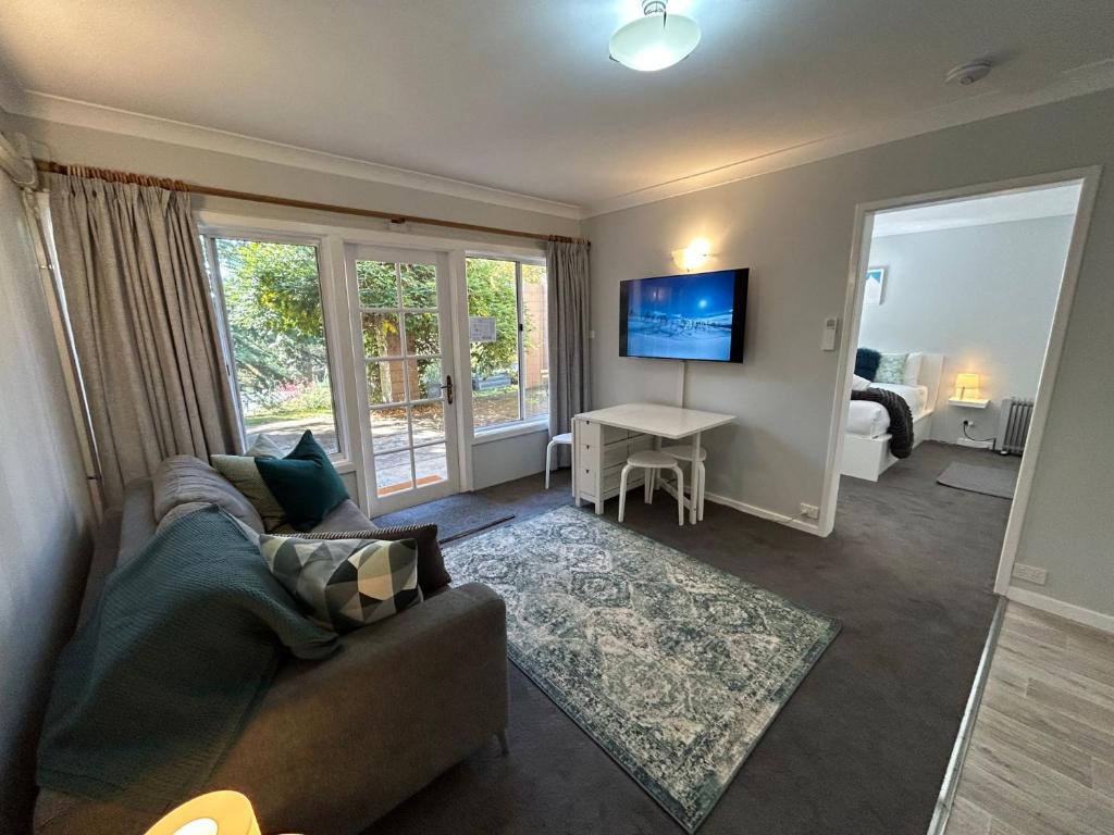 sala de estar con sofá y mesa con TV en Vaby s 1, en Jindabyne