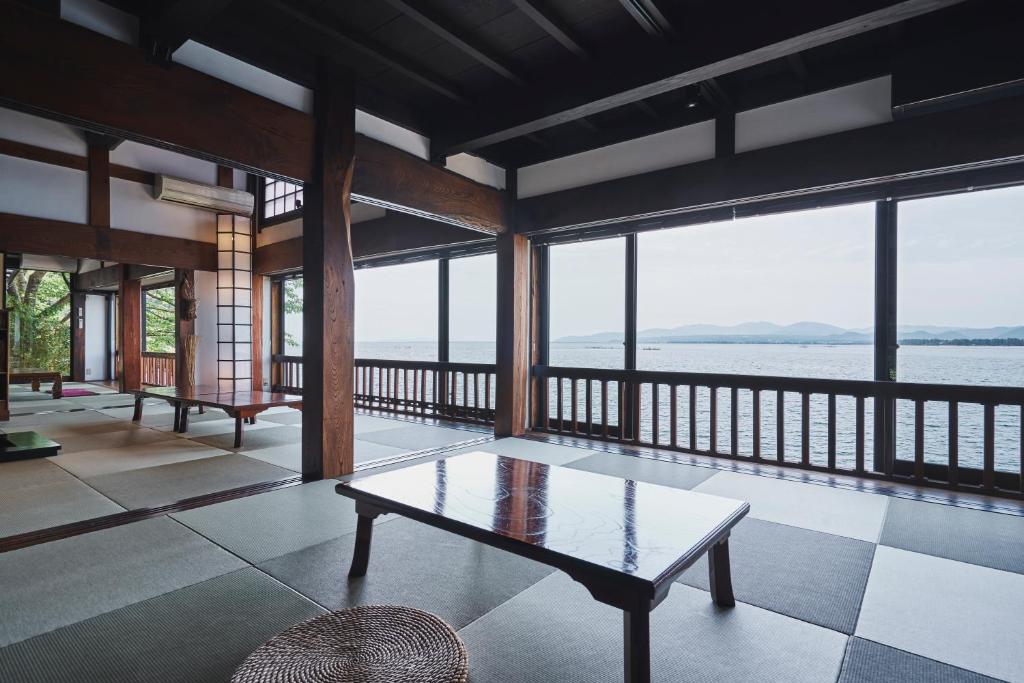 奥琵琶湖　四季亭 في Kaizu: غرفة معيشة مع طاولة وإطلالة على الماء