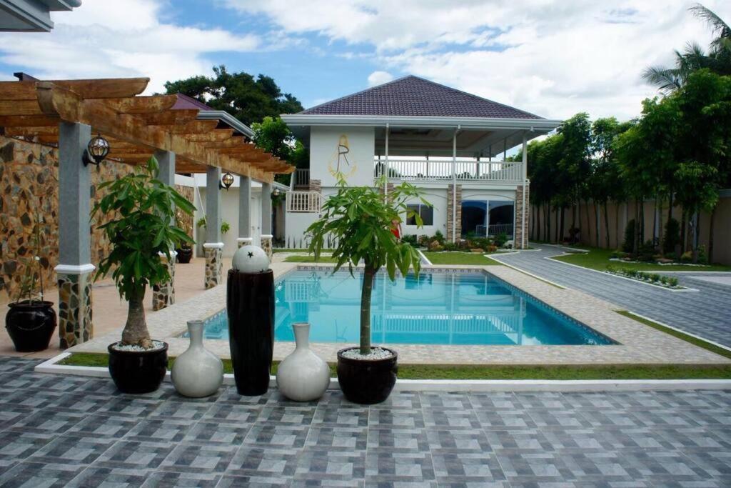 una casa con una piscina con jarrones alrededor en La Romana Countryside Haven en Anao